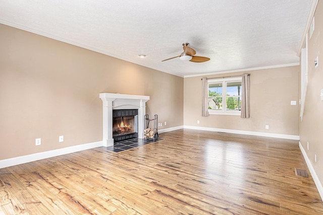 51268 Channel Ct, Elkhart, IN 46514 - unfurnished living room with a ceiling fan, wood finished floors, a fireplace with flush hearth, ornamental molding, and a textured ceiling