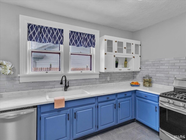 1310 W Jefferson Blvd, Fort Wayne, IN 46802 - kitchen with stainless steel appliances, blue cabinetry, decorative backsplash, white cabinets, and a textured ceiling
