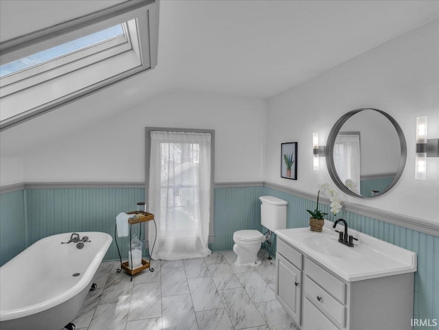 1310 W Jefferson Blvd, Fort Wayne, IN 46802 - bathroom featuring wainscoting, lofted ceiling, marble finish floors, a freestanding bath, and vanity