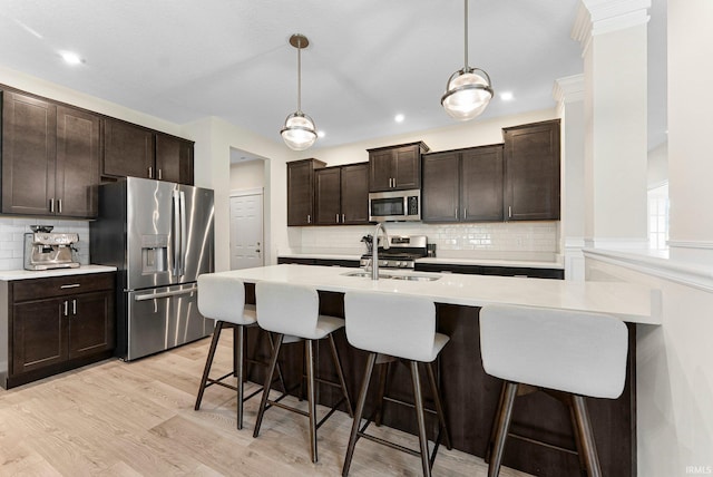 1114 Mosaic St, Huntertown, IN 46748 - kitchen with appliances with stainless steel finishes, light wood-style floors, decorative backsplash, light countertops, and recessed lighting