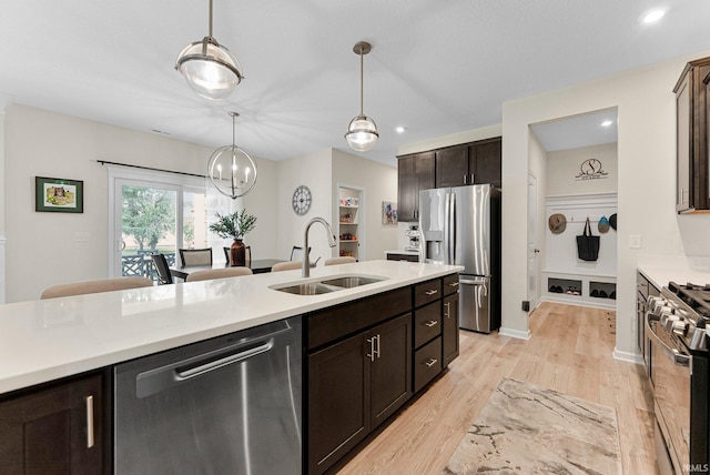 1114 Mosaic St, Huntertown, IN 46748 - kitchen featuring appliances with stainless steel finishes, light countertops, light wood-type flooring, dark brown cabinetry, and decorative light fixtures