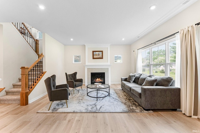 1114 Mosaic St, Huntertown, IN 46748 - living room with wood finished floors, a glass covered fireplace, stairs, and recessed lighting