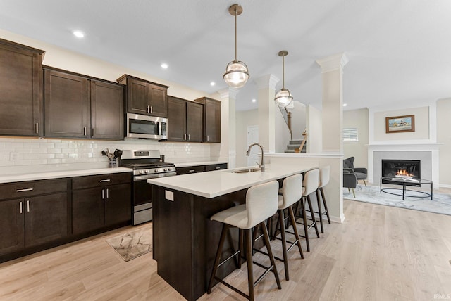 1114 Mosaic St, Huntertown, IN 46748 - kitchen with appliances with stainless steel finishes, light wood-style floors, a kitchen bar, decorative backsplash, and recessed lighting