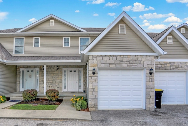 5972 N Ajuga Ct, Ellettsville, IN 47429 - view of front of house featuring stone siding, a shingled roof, a porch, a garage, and driveway
