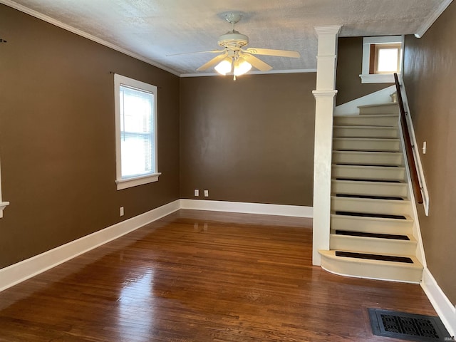 2103 Kentucky Ave, Fort Wayne, IN 46805 - unfurnished living room featuring plenty of natural light, wood finished floors, ceiling fan, stairway, and ornamental molding