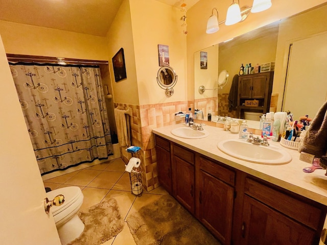 7640 Union Rd, Plymouth, IN 46563 - bathroom featuring tile patterned floors, double vanity, tile walls, and wainscoting
