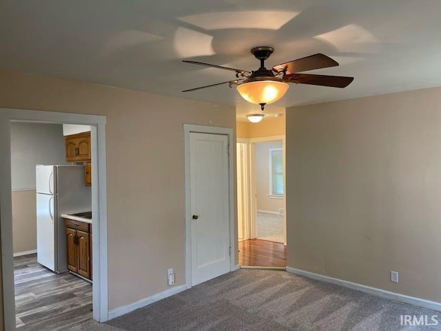 2056 Riedmiller Ave, Fort Wayne, IN 46802 - unfurnished bedroom with freestanding refrigerator, carpet flooring, and ceiling fan