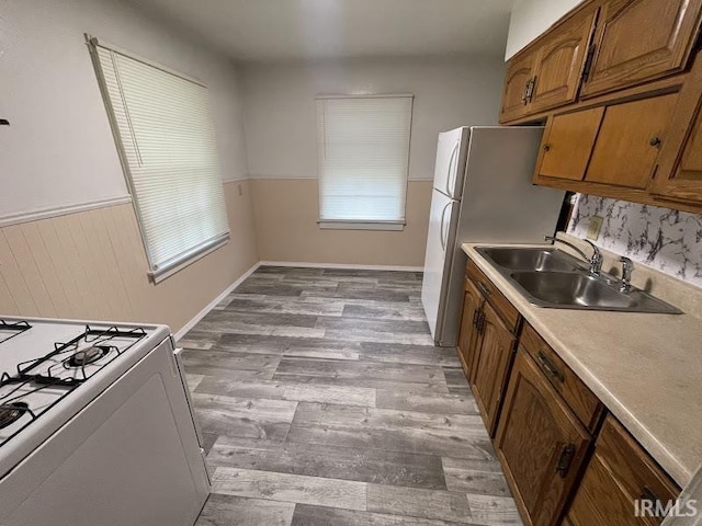 2056 Riedmiller Ave, Fort Wayne, IN 46802 - kitchen with white appliances, wood finished floors, brown cabinetry, and light countertops