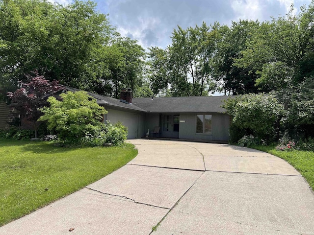 3215 Wakashan Pl, Fort Wayne, IN 46815 - view of front of house featuring a front yard, a garage, concrete driveway, and a chimney