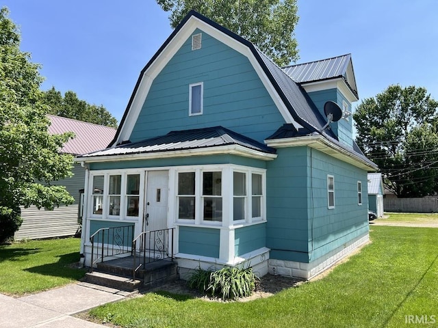 126 E Washington St, Monroe, IN 46772 - colonial inspired home featuring a metal roof, a front lawn, and a gambrel roof
