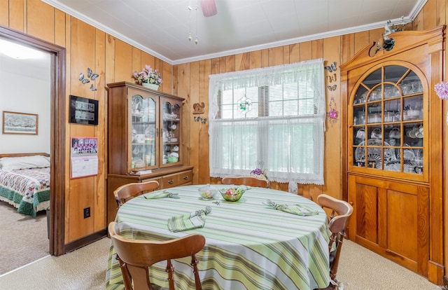 3721 Claremont Ave, Evansville, IN 47712 - dining space with light carpet, crown molding, wood walls, and a ceiling fan