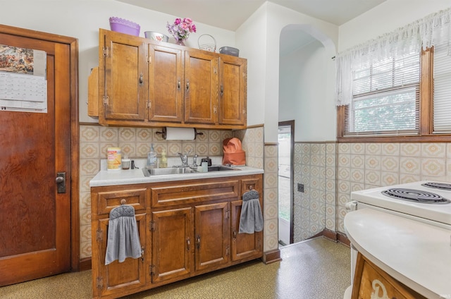3721 Claremont Ave, Evansville, IN 47712 - kitchen with light countertops, wainscoting, light flooring, brown cabinets, and tile walls