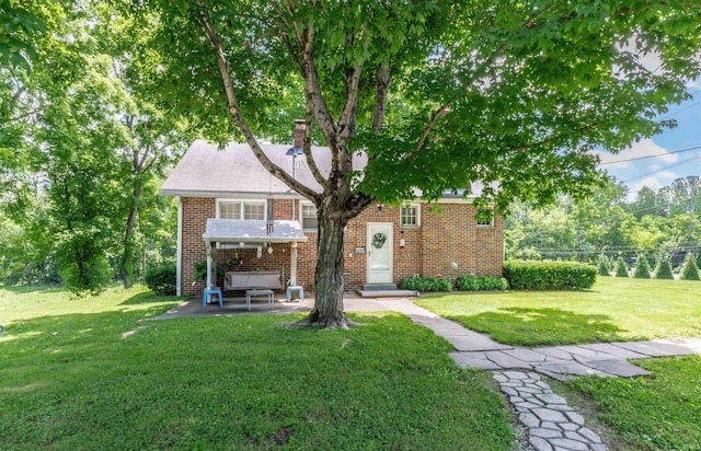 3721 Claremont Ave, Evansville, IN 47712 - view of front facade with a chimney, brick siding, a front yard, and a patio area