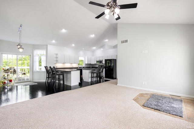 26973 Water Edge Dr, Elkhart, IN 46514 - kitchen featuring freestanding refrigerator, a kitchen breakfast bar, stainless steel microwave, white cabinets, and dark countertops