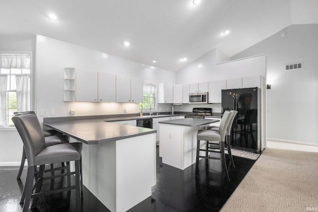 26973 Water Edge Dr, Elkhart, IN 46514 - kitchen featuring black appliances, a kitchen breakfast bar, a peninsula, white cabinets, and dark countertops