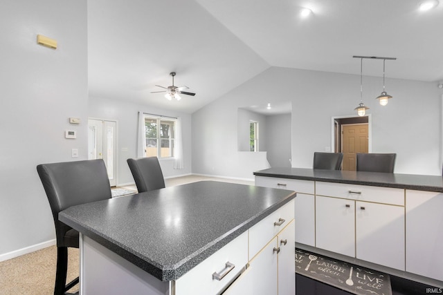 26973 Water Edge Dr, Elkhart, IN 46514 - kitchen featuring dark countertops, vaulted ceiling, white cabinetry, a ceiling fan, and hanging light fixtures