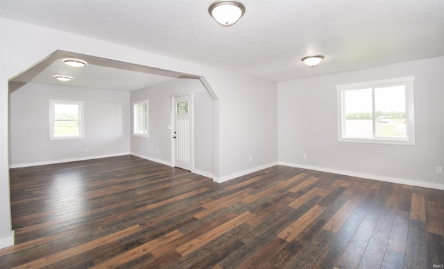 3046 Long Lake Rd, Albion, IN 46701 - spare room featuring dark wood-style floors, a textured ceiling, and arched walkways
