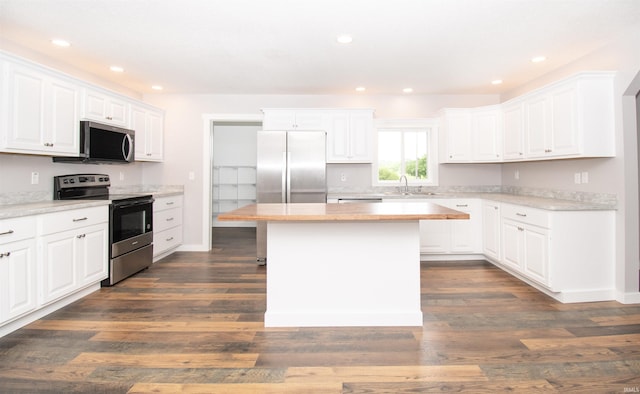 3046 Long Lake Rd, Albion, IN 46701 - kitchen with stainless steel appliances, a kitchen island, light countertops, white cabinets, and dark wood-style flooring