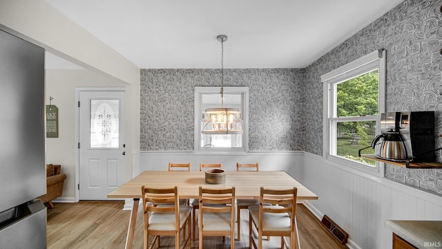 1897 Lakeshore Dr, Walkerton, IN 46574 - dining space with wainscoting, light wood-style flooring, a chandelier, and wallpapered walls