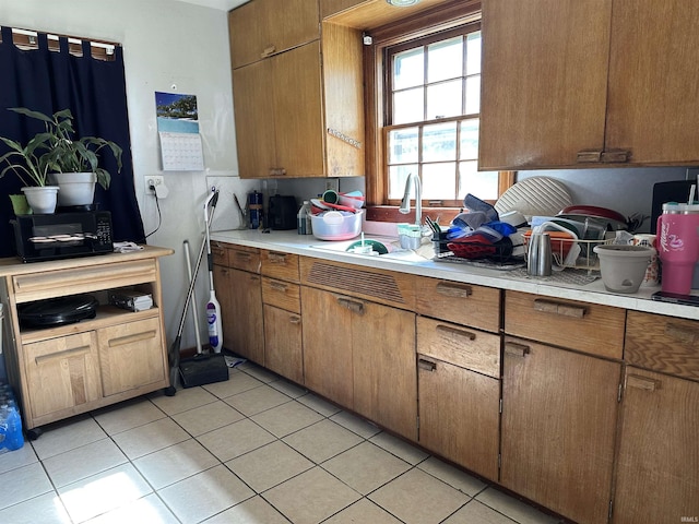2816 E Morgan Ave, Evansville, IN 47711 - kitchen with light countertops, light tile patterned floors, and brown cabinetry