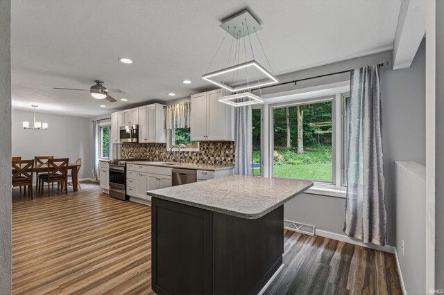 953 Handlebar Rd, Mishawaka, IN 46544 - kitchen with appliances with stainless steel finishes, dark wood-style floors, a chandelier, decorative backsplash, and white cabinets