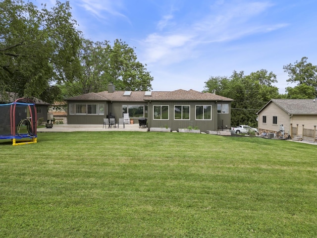 3865 E Forest Glen Ave, Leesburg, IN 46538 - back of property with a trampoline, a chimney, a patio area, and a yard