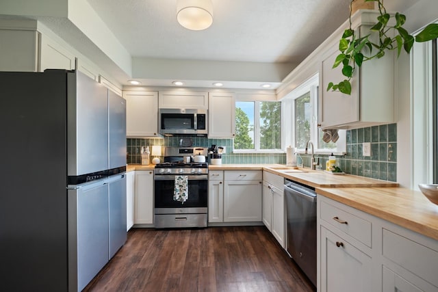 3865 E Forest Glen Ave, Leesburg, IN 46538 - kitchen featuring stainless steel appliances, butcher block counters, backsplash, dark wood-style flooring, and white cabinetry