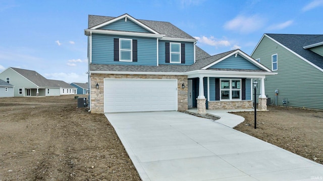 10263 Tirian Pl, Fort Wayne, IN 46835 - craftsman-style home with stone siding, driveway, covered porch, a garage, and a shingled roof