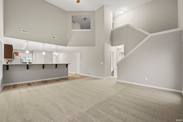 10263 Tirian Pl, Fort Wayne, IN 46835 - unfurnished living room featuring light colored carpet, a towering ceiling, and ceiling fan