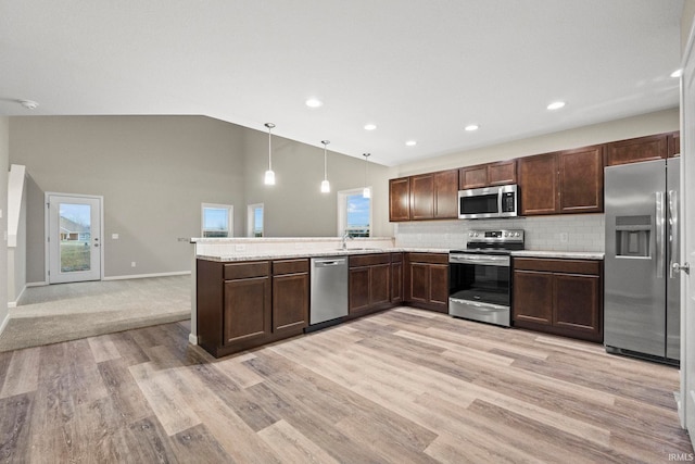 10263 Tirian Pl, Fort Wayne, IN 46835 - kitchen with stainless steel appliances, a peninsula, light countertops, dark brown cabinets, and high vaulted ceiling