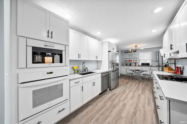 241 Sylvan Glen Dr, South Bend, IN 46615 - kitchen with stainless steel appliances, light countertops, light wood-style flooring, white cabinetry, and recessed lighting