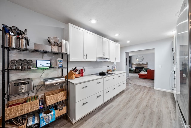 241 Sylvan Glen Dr, South Bend, IN 46615 - kitchen featuring under cabinet range hood, white cabinetry, light countertops, light wood-type flooring, and recessed lighting