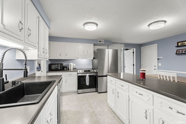 17135 Old 24 Rd, Woodburn, IN 46797 - kitchen featuring stainless steel appliances, dark countertops, white cabinets, and a textured ceiling
