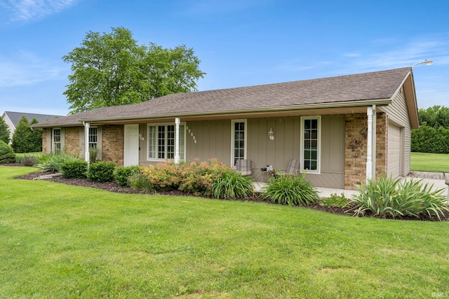 17135 Old 24 Rd, Woodburn, IN 46797 - ranch-style house featuring an attached garage, a front yard, roof with shingles, and covered porch