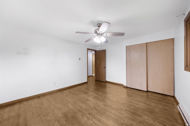 1545 Werling Rd, New Haven, IN 46774 - unfurnished bedroom with a baseboard heating unit, wood finished floors, a closet, and a ceiling fan