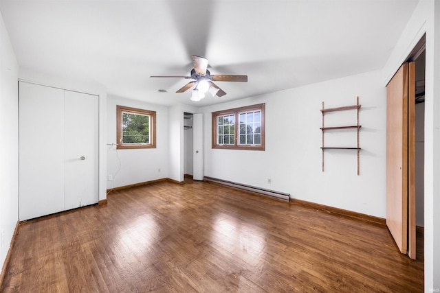 1545 Werling Rd, New Haven, IN 46774 - unfurnished bedroom with a baseboard radiator, two closets, wood finished floors, and a ceiling fan