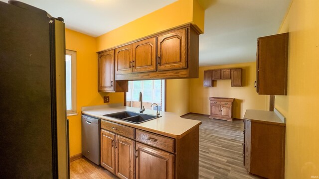 3557 N 150 E, Camden, IN 46917 - kitchen with stainless steel dishwasher, brown cabinets, a peninsula, light wood-type flooring, and light countertops