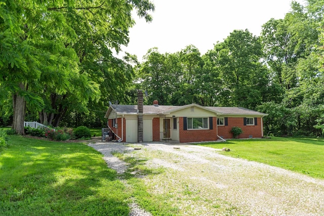 3557 N 150 E, Camden, IN 46917 - ranch-style house featuring gravel driveway, a chimney, brick siding, a front yard, and view of wooded area