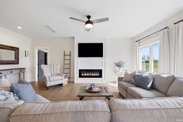 4685 N Triple Crown Dr, Bloomington, IN 47404 - living room with wood finished floors, ceiling fan, a glass covered fireplace, and recessed lighting