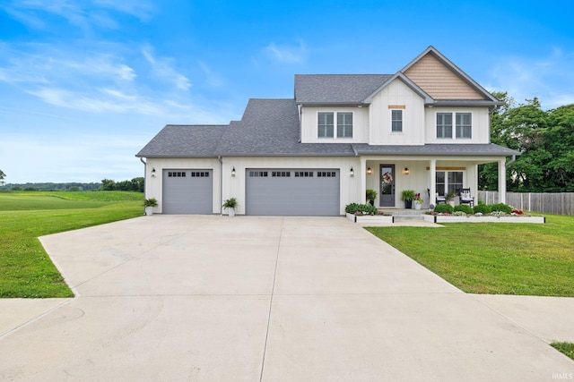 4685 N Triple Crown Dr, Bloomington, IN 47404 - view of front of home with concrete driveway, an attached garage, covered porch, board and batten siding, and roof with shingles