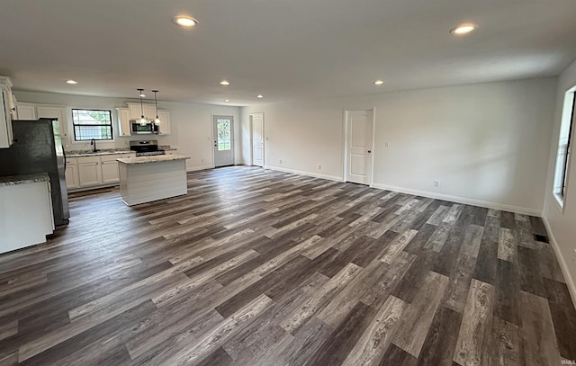 1405 Rosewood Dr, Washington, IN 47501 - unfurnished living room with recessed lighting, plenty of natural light, and dark wood-type flooring