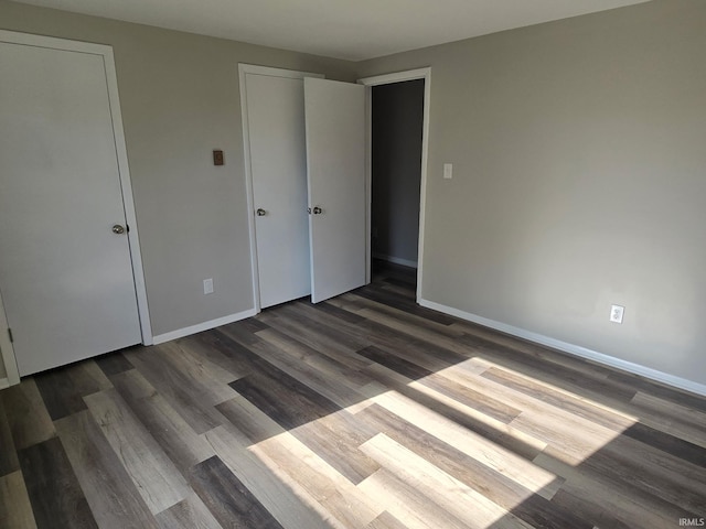 104 Fremont Ln, Decatur, IN 46733 - unfurnished bedroom with dark wood-style floors and baseboards