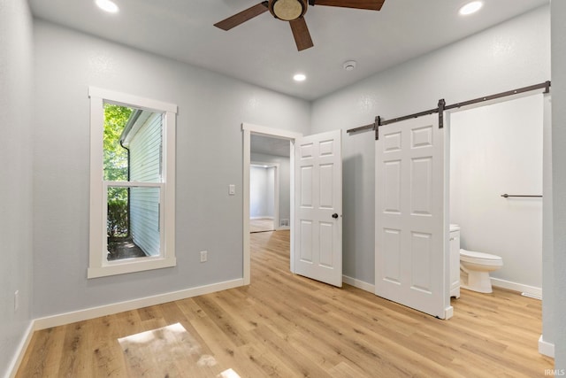 610 N 5th St, Goshen, IN 46528 - unfurnished bedroom with light wood-style floors, a barn door, recessed lighting, connected bathroom, and a ceiling fan