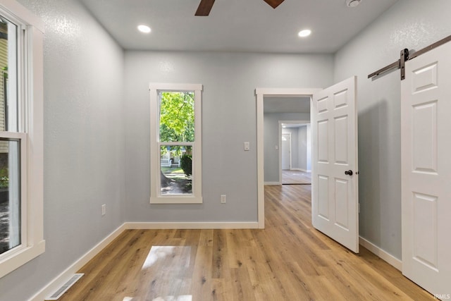 610 N 5th St, Goshen, IN 46528 - unfurnished room with a barn door, ceiling fan, light wood-type flooring, and recessed lighting