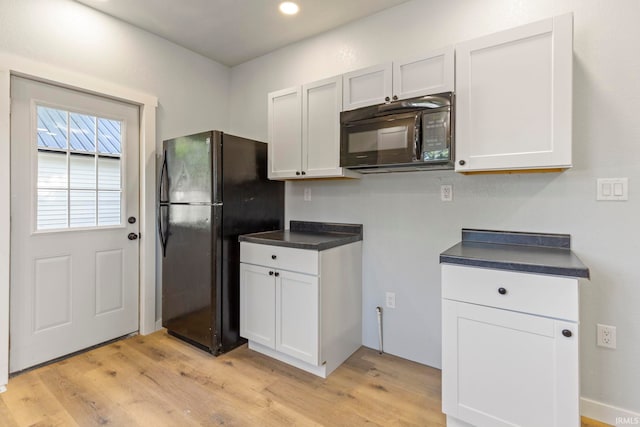 610 N 5th St, Goshen, IN 46528 - kitchen with black appliances, light wood-type flooring, dark countertops, recessed lighting, and white cabinetry