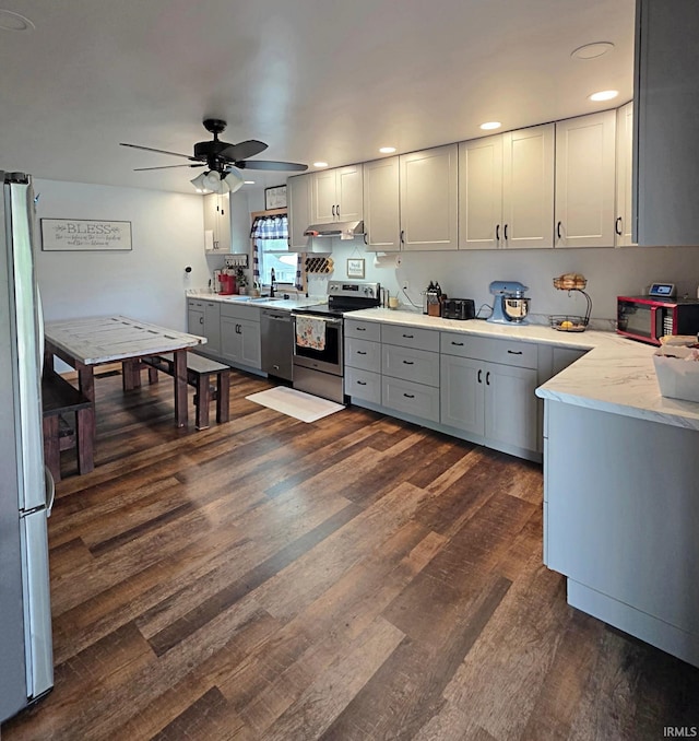 826 SE 2nd St, Washington, IN 47501 - kitchen featuring appliances with stainless steel finishes, gray cabinetry, dark wood finished floors, ceiling fan, and under cabinet range hood