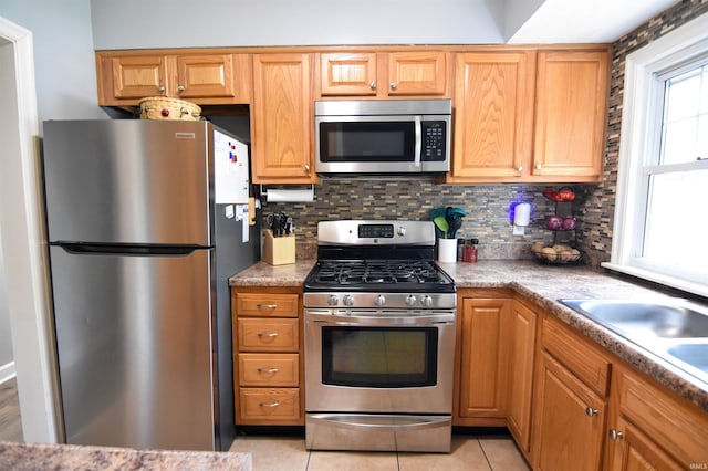 2221 Washington Ave, Evansville, IN 47714 - kitchen with stainless steel appliances, backsplash, light tile patterned flooring, and light countertops