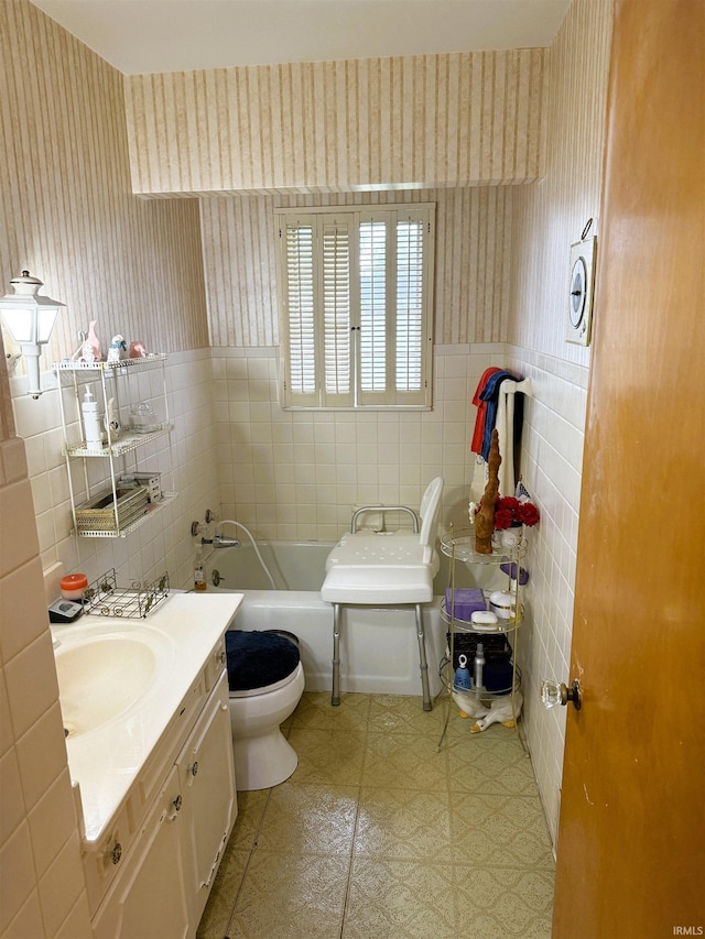 100 S Fairlawn Ave, Evansville, IN 47714 - bathroom with tile walls, wallpapered walls, a bath, vanity, and a wainscoted wall