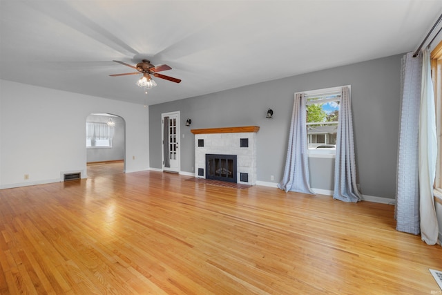 501 N Van Buren St, Auburn, IN 46706 - unfurnished living room with light wood-style floors, ceiling fan, arched walkways, and a fireplace with flush hearth