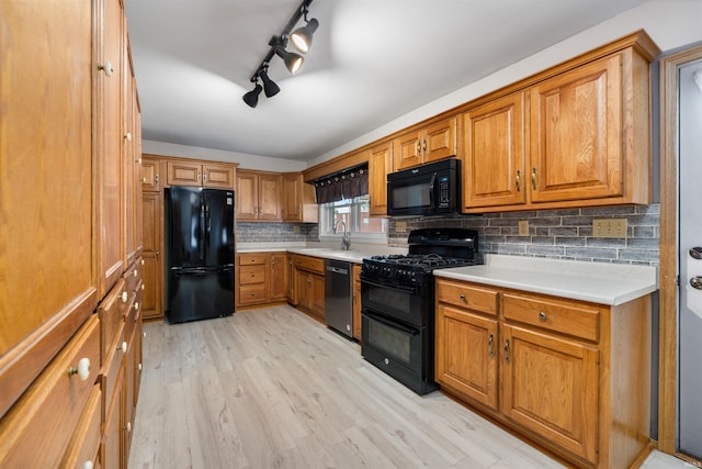 501 N Van Buren St, Auburn, IN 46706 - kitchen with black appliances, brown cabinets, decorative backsplash, and light wood-style flooring